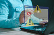 © Montri - Businessman using computer laptop with triangle caution warning sing for notification error and maintenance concept...