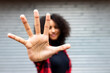 © Westend61 - Woman showing stop sign gesture in front of shutter