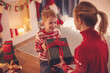 © candy1812 - Mother giving Christmas gift box to her cute son.