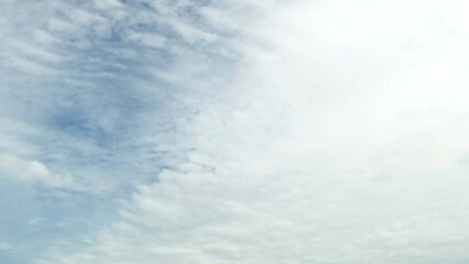 Wall Mural - White puffy clouds and a blue clear sky timelapse. Beautiful background of skyscrapers.