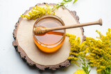 Fototapeta Tulipany - jar of honey and honey dipper on a light background, top view.