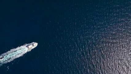 Wall Mural - high aerial view of a luxury yacht crossing the blue ocean with speed