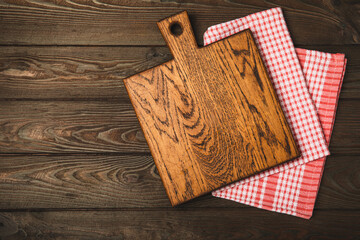 Wall Mural - Cutting board over towel on wooden kitchen table. Cutting board and kitchen towel on a cement background. Menu food card or recipes background concept.MOCKUP. Design. Place for text, copy space.