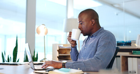 Wall Mural - Office, black man with desk with laptop and coffee, drinking and typing report, review or research article. Computer, internet and businessman with cup of tea writing blog, feedback or online editing