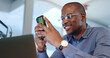 © Anela R/peopleimages.com - Happy black man, phone and typing at office in communication, social media or networking. African businessman smile on mobile smartphone app for online chatting, texting or research at workplace
