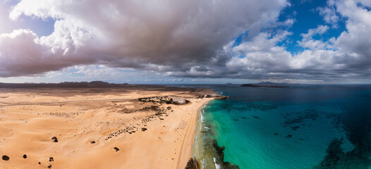 Wall Mural - Panoramic high angle aerial drone view of Corralejo National Park (Parque Natural de Corralejo) with sand dunes located in the northeast corner of the island of Fuerteventura, Canary Islands, Spain.