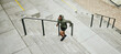 © Malambo C/peopleimages.com - Fitness, city and black man running on stairs outdoor, exercise and training healthy body in urban town top view. Sports, cardio and African athlete on steps for workout, energy and jog for wellness
