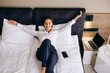 © Petro - Business woman lying on a bed in a hotel room
