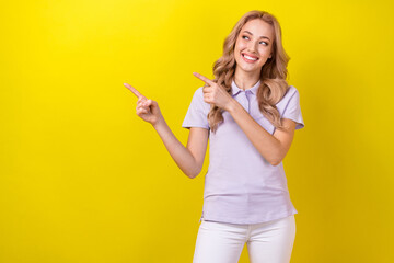 Poster - Photo of stunning cheerful girl toothy smile look indicate fingers empty space isolated on yellow color background