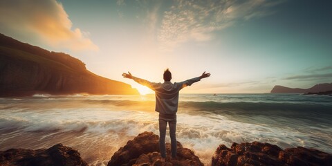 Wall Mural - Young man arms outstretched by the sea at sunrise enjoying freedom and life, people travel wellbeing concept