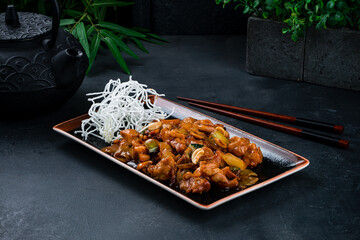 Sticker - Chicken with onion, celery, cashew nuts in sauce with chopsticks on a dark background.