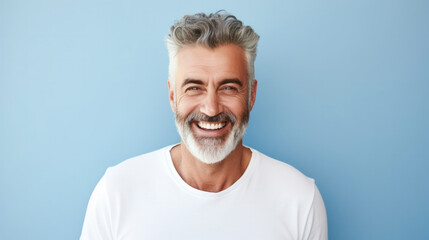 Wall Mural - Portrait of handsome bearded elderly man keeps self confident cheerful expression at camera wears formal shirt and spectacles for vision correction isolated on blue wall