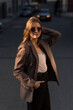 © Павел Костенко - Portrait of a Caucasian attractive and happy young woman in casual clothes and sunglasses in the city while walking on a sunny day. The concept of style, fashion, youth and lifestyle