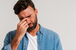 © Tymon - Caucasian man with closed eyes in blue shirt with severe headache