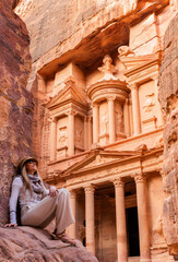 Wall Mural - Blonde woman in spectacular view of Al Khazneh (The Treasury), ancient city of Petra, Jordan