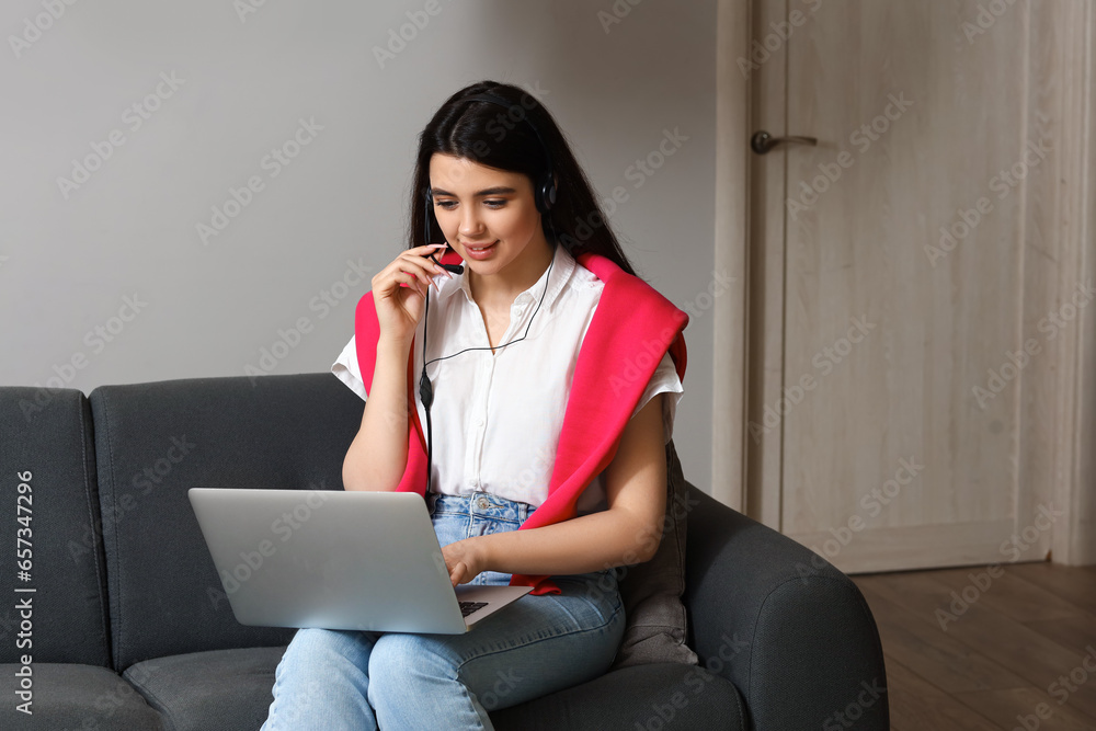 Female technical support agent with laptop working at home