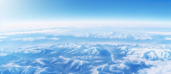 Wall Mural - Winter landscape of snow covered mountains viewed from an airplane