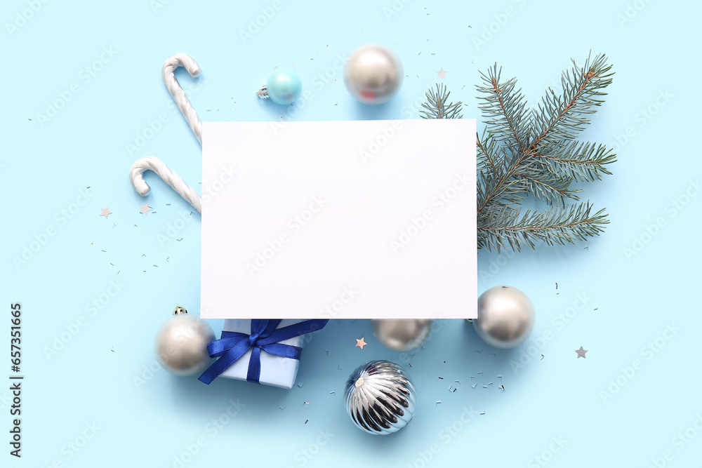 Blank card with Christmas tree branch, balls, candy canes and gift box on blue background