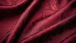 Texture of a brocade fabric in a rich burgundy color, with raised motifs in a paisley pattern. The fabric has a subtle sheen and a slightly rough texture, adding a unique depth to the design.