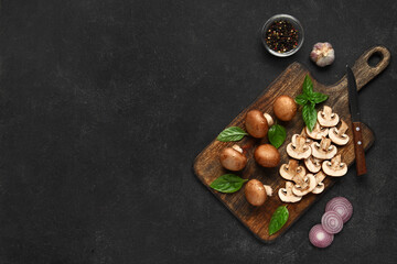 Canvas Print - Wooden board with fresh mushrooms and different spices on black background