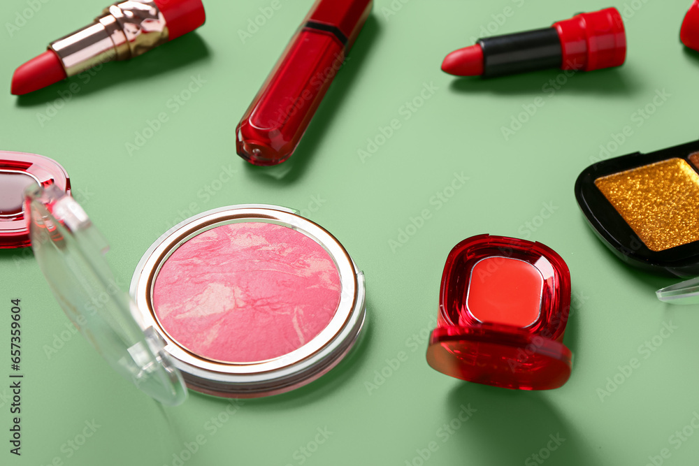 Different decorative cosmetics on green background