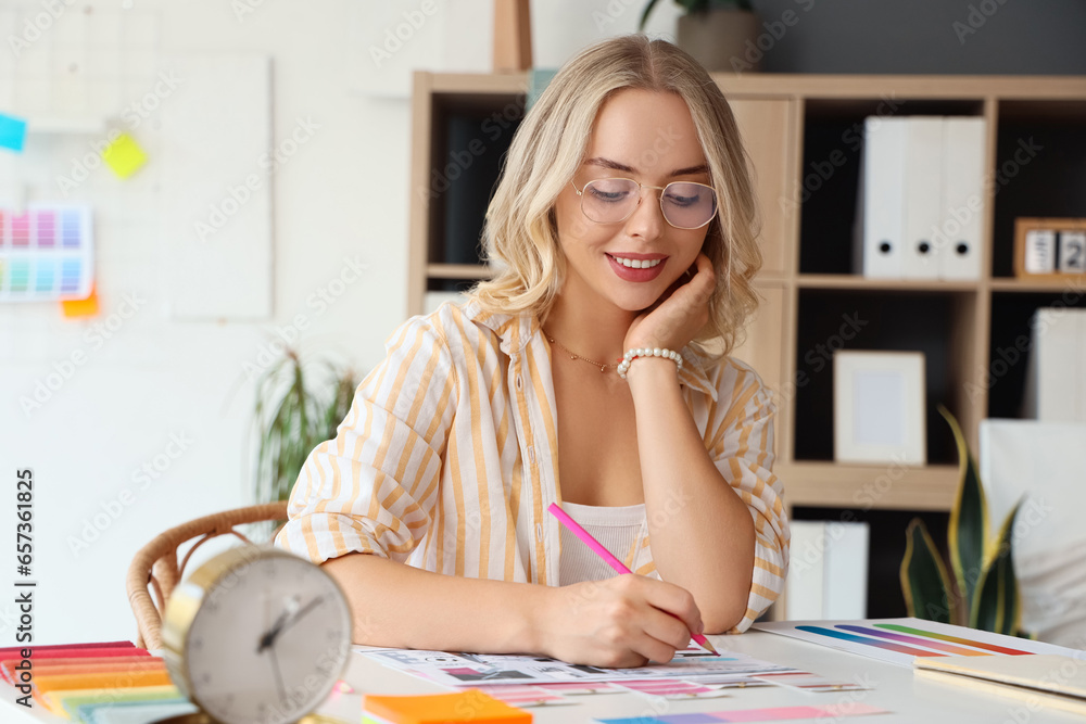 Female interior designer drawing at table in office