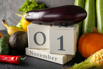 Fresh vegetables, fruits and cube calendar with date NOVEMBER 1 on table. World Vegan Day concept