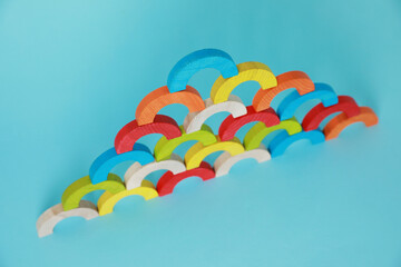 Wall Mural - Colorful wooden pieces of playing set on light blue background. Educational toy for motor skills development