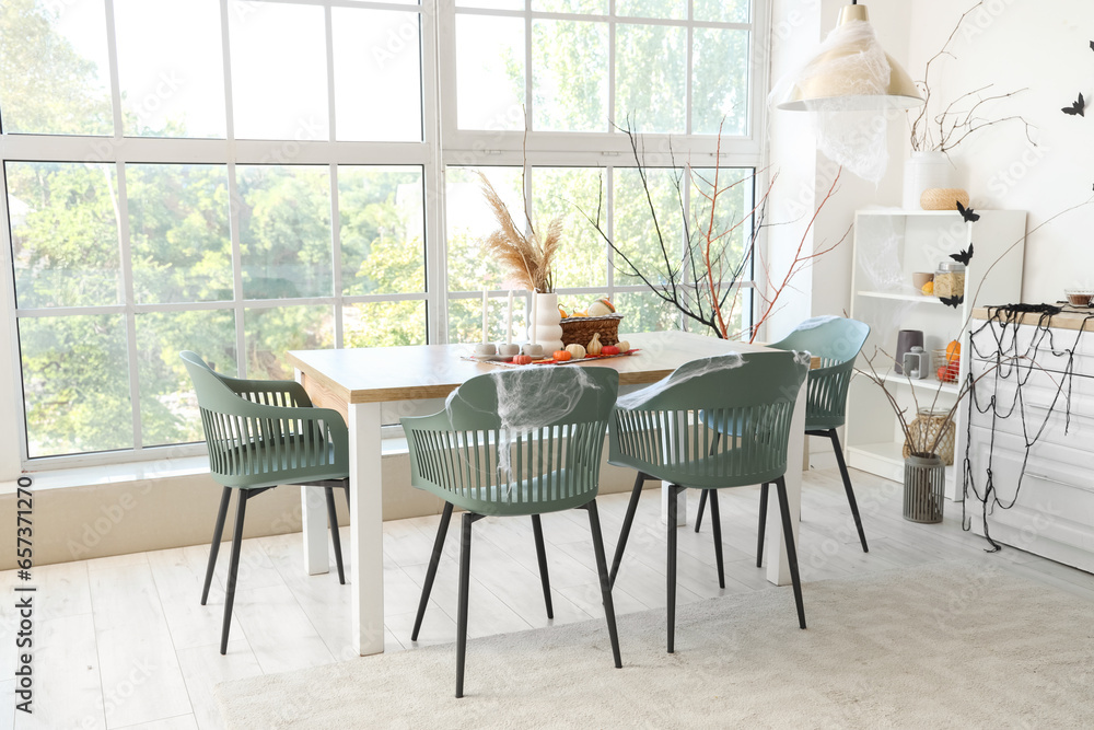 Interior of light kitchen decorated for Halloween with dining table