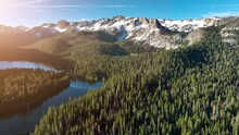 Aerial Shot Of A Tranquil Lake At Dawn, Reflecting The Surrounded Forest And Mountains. In The Sierra Nevada Mountains Near Mammoth Lakes California.