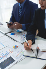 Wall Mural - Business team Negotiation, Analysis, Discussion, Asian woman economist and marketer pointing to a financial data sheet to plan investments to prevent risks and losses for the company