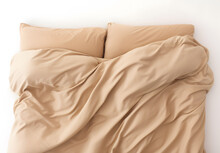 The Head Of A Bed Set Done In Tan Sheets And Pillow Cases, Isolated On White; Messy Comforter