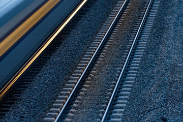 Moving passenger train next to a second set of tracks. Blurred train car and lights.	