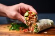 hand inserting bamboo skewer in burrito to hold it together