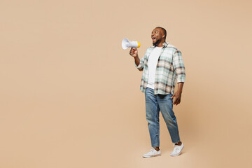 Wall Mural - Full body young man of African American ethnicity he wear light shirt casual clothes hold in hand megaphone scream announces discounts sale Hurry up isolated on plain pastel beige background studio.