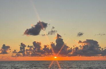 Wall Mural - bright orange sunset and sea beach. sun steam and sun rays and dark romantic cloud