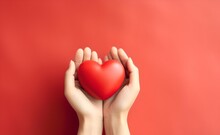 Young Women Hands Holding Red Heart On Red Pastel Background.