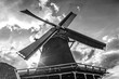 sun shining throug old dutch windmill in black and white