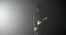 Silhouette Of Expressive Rocker Performing On Electric Guitar