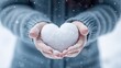 Human hands hold heart shape snow