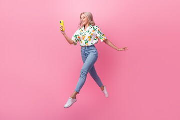 Sticker - Full body photo of running fast model blonde wavy hair bring phone cant stop using her new iphone jumping isolated on pink color background