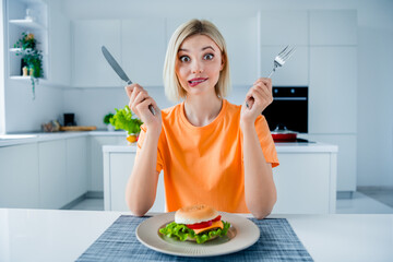 Poster - Photo of puzzled pretty lady hands hold fork knife biting lips burger plate kitchen table bright house inside