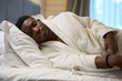 Man in terry robe fell asleep sweetly on large bed