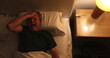 © Marco - Person waking up at night, turning bedside light ON, man stretching and getting up from bed