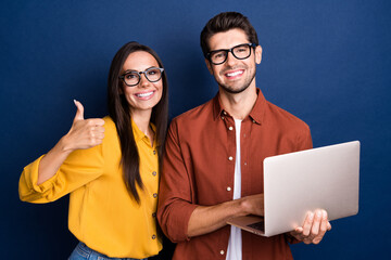 Fototapete - Photo of successful businesspeople hold netbook demonstrate thumb up confirmation isolated on blue color background