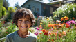 Happy 10 year old boy standing in a vibrant garden with flowers.
