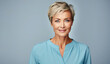 © Anzhela - Portrait of beautiful gorgeous 50s mid elderly tanned modern woman with short haircut in blue blouse on blue background, Copy space
