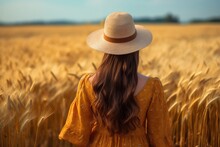 Back View Of A Girl Wearing Hat Standing At Ripe Wheat Field ,Generative AI .