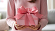 ピンクのプレゼントを渡す女性 Girl giving pink gift box