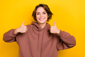 Sticker - Photo of charming woman lady raise thumbs up approve good quality agree wear brown hood shirt isolated yellow color background